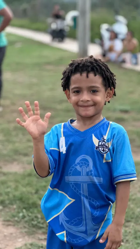 Niño de Chuter FC saludando a la cámara con su uniforme azul