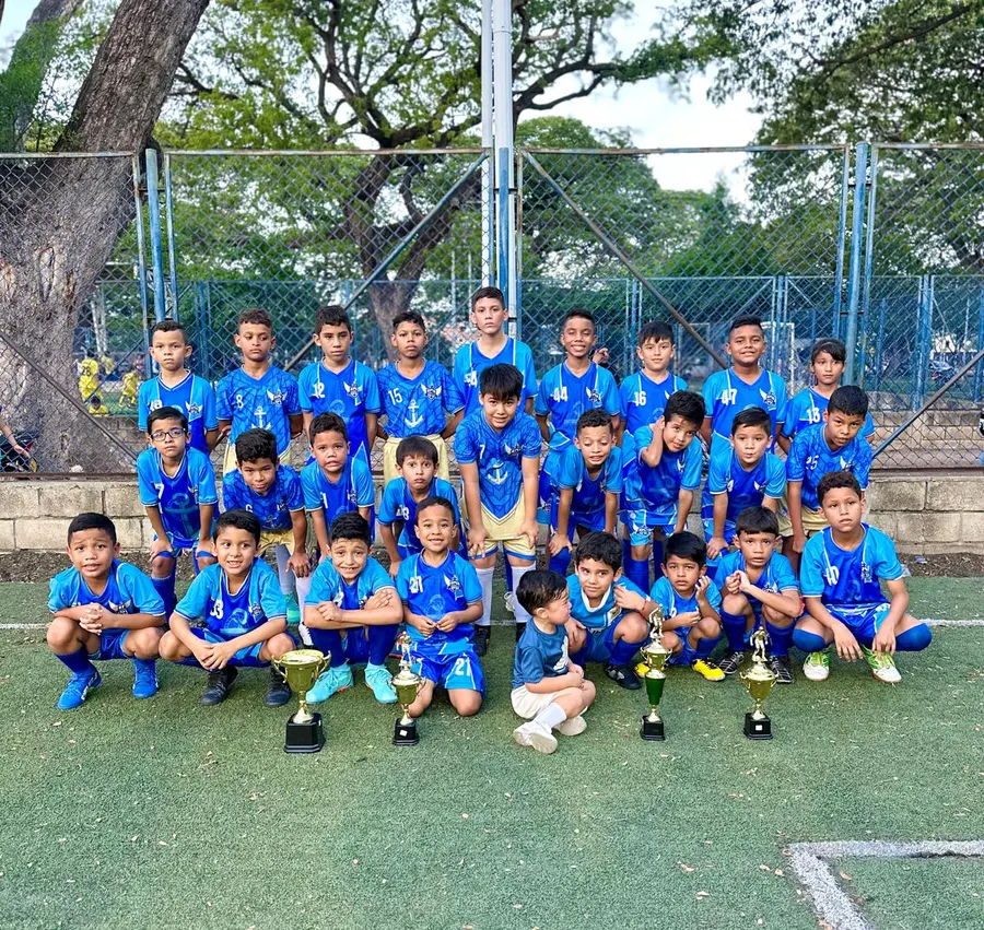 Plantel de Chuter FC posando en la cancha con cinco trofeos