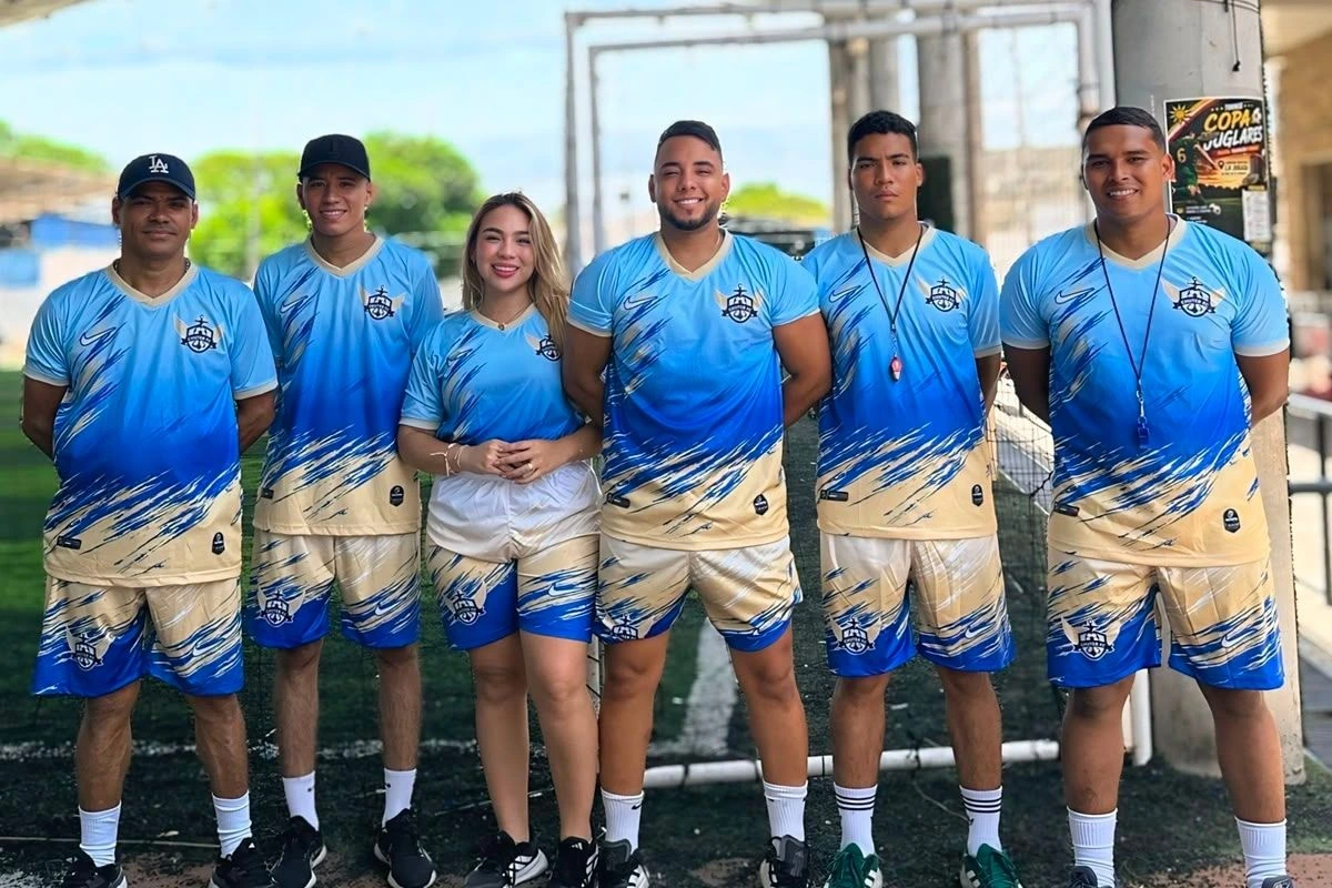 Los seis integrantes del cuerpo técnico de Chuter FC posando en la cancha con el uniforme del club