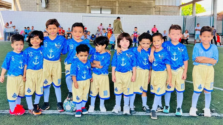 Grupo de niños de Chuter FC abrazados posando juntos