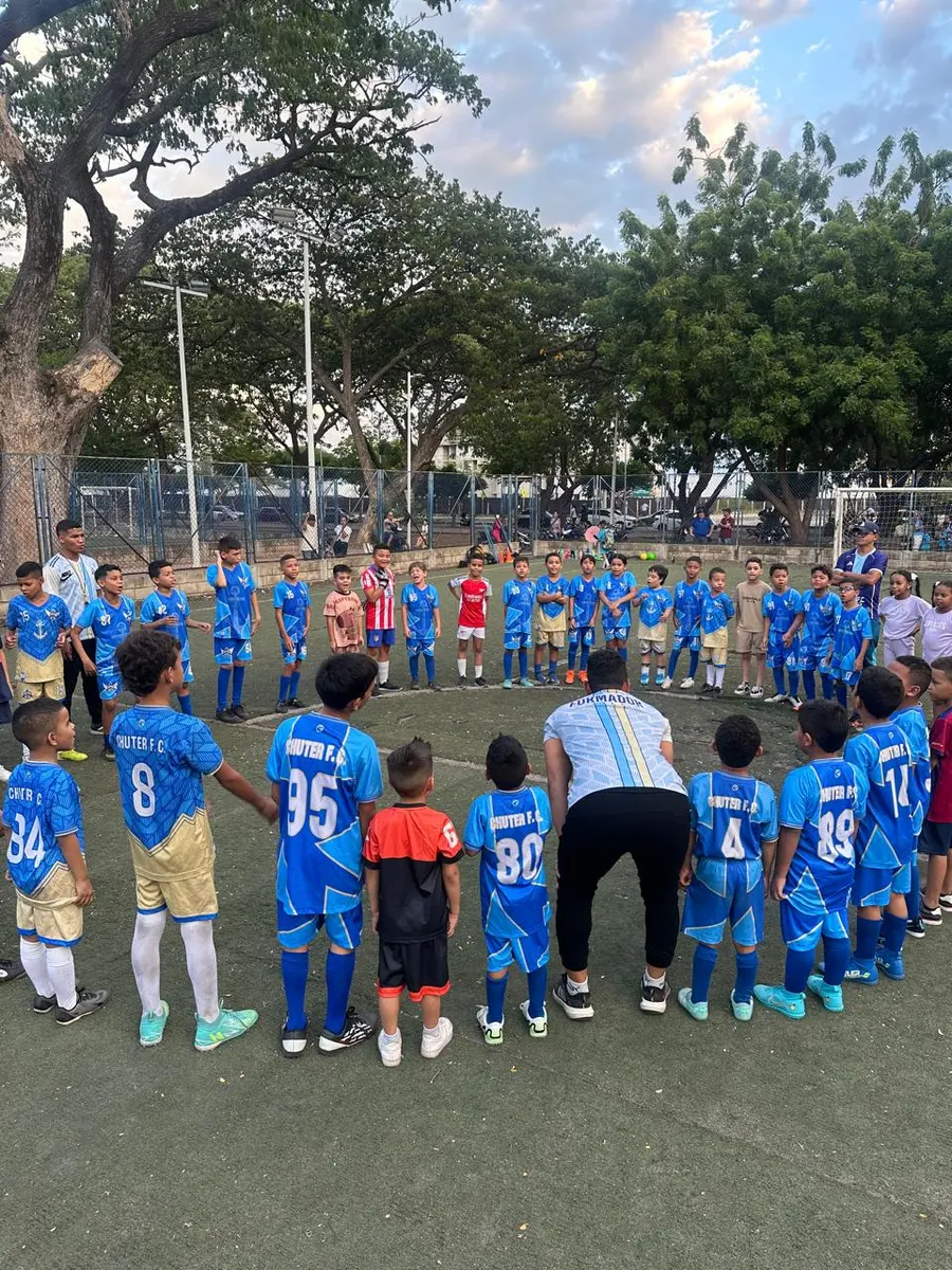 Equipo de Chuter FC en círculo alrededor del formador al atardecer