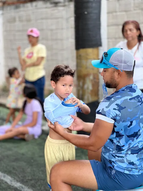 Entrenador de Chuter FC dándole agua a uno de los niños