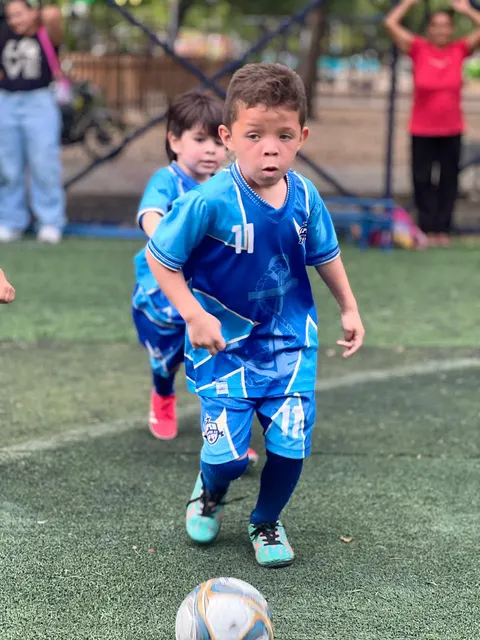 Niño de Chuter FC corriendo con el balón durante el entrenamiento